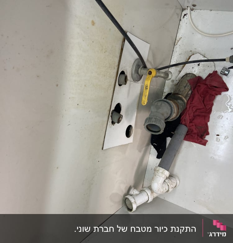 צינורות מתחת לכיור עם ברז צהוב